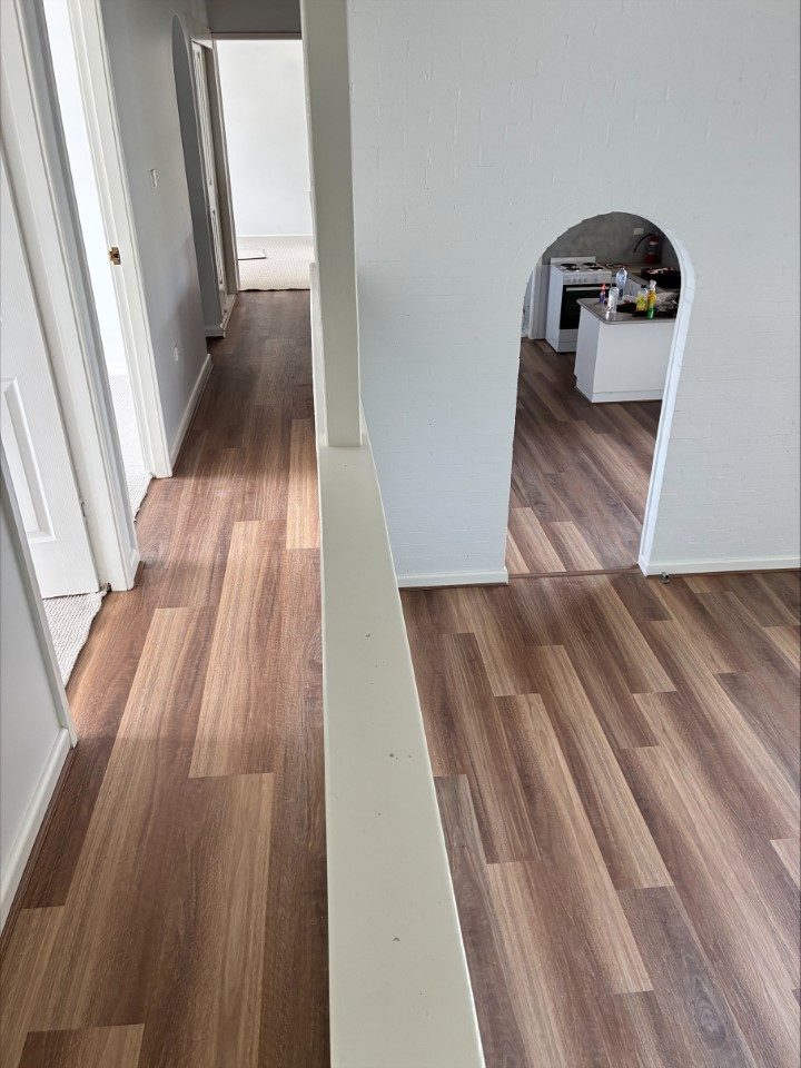 Timber flooring leading through an arched hallway