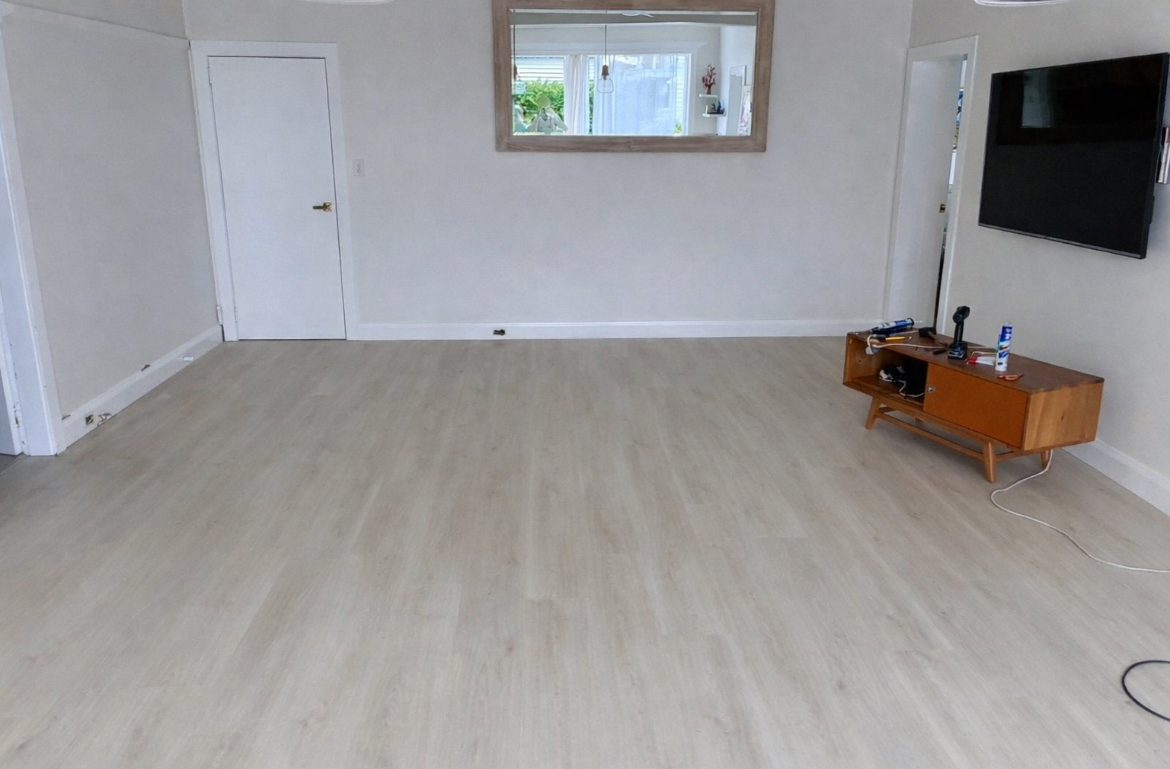 Light hybrid plank flooring in a furnished living room